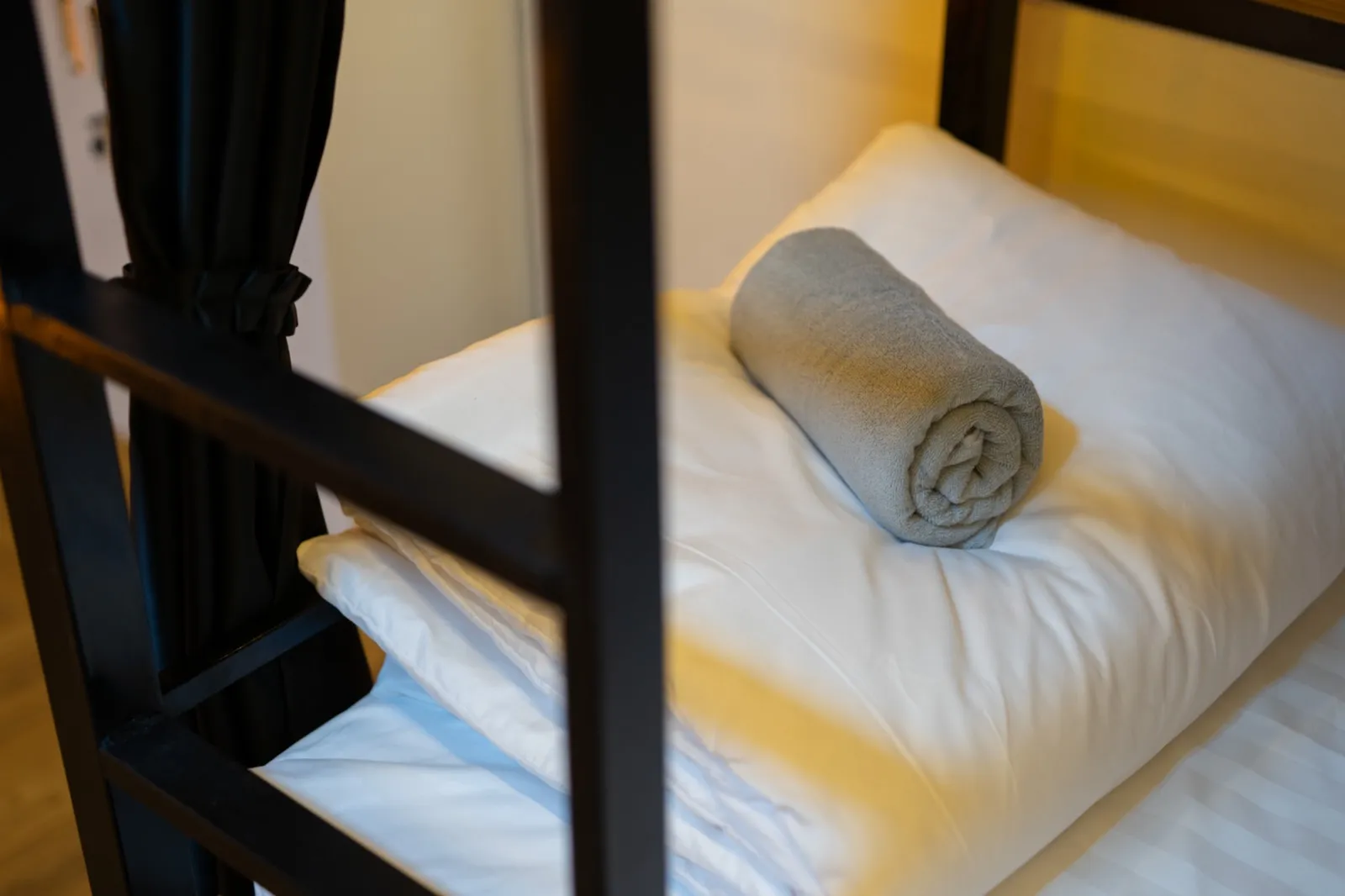 Fresh pillow and towel on a made dorm bed at The Hub Laidback Hostel, Ao Nang